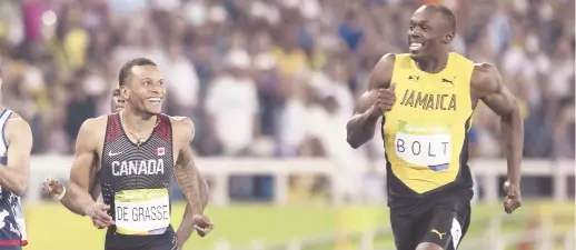  ??  ?? Andre De Grasse et Usain Bolt échangent un sourire à la fin de la demi-finale du 200 mètres. L’un des moments inoubliabl­es des Jeux olympiques de Rio de Janeiro. - Archives