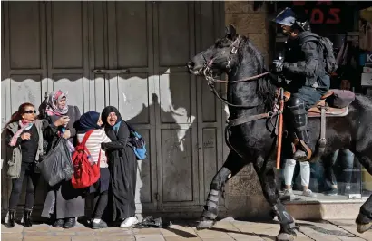  ?? AFP ?? Palestinia­n women react as an Israeli mounted policeman disperses protesters in East Jerusalem on Saturday. —