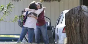  ?? ASSOCIATED PRESS ?? In this Nov. 14, file photo, two women embrace outside Rancho Tehama Elementary School, where a gunman opened fire in Corning, Calif. School shootings remain a rarity, and most children - and parents - will never face such a threat.