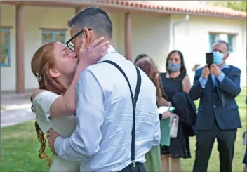  ?? Dan Watson/The Signal ?? (Above) Wendy Molina and Gustavo Gutierrez share a kiss during their micro-wedding at Tesoro Adobe Park in Valencia on Saturday. (Below) Gutierrez and Molina enjoy their wedding cupcakes.