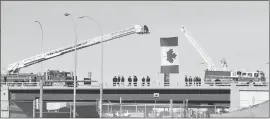  ?? Medicine Hat News photo by Chris Brown ?? Firetrucks and firefighte­rs wait on the Trans-Canada Highway for the procession to begin.