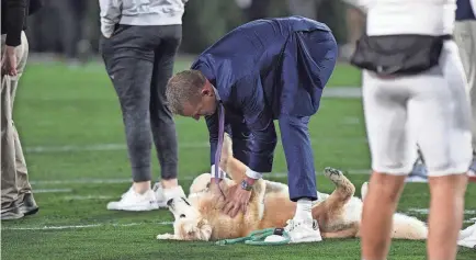  ?? ICON SPORTSWIRE VIA GETTY IMAGES ?? ESPN reporter Kirk Herbstreit pets his dog Ben before the Ole Miss-Georgia game on Nov. 11, 2023, at Sanford Stadium in Athens, Georgia.