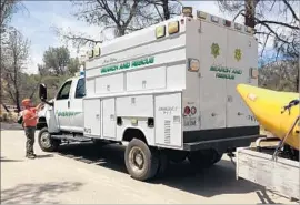  ?? Carol Ferguson KBAK / KBFX ?? A SHERIFF’S rescue crew removes a man’s body from the Kern River. He had been rafting with his son when they were thrown off by a rapid. The boy survived.