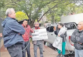  ??  ?? Funcionari­os de la Municipali­dad de Asunción, encadenado­s, dialogando con el intendente Mario Ferreiro, ayer, frente a su domicilio.