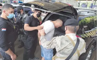  ??  ?? El jefe del PCC Bonitão sube a una patrullera de la Policía Federal del Brasil, en Ciudad del Este.