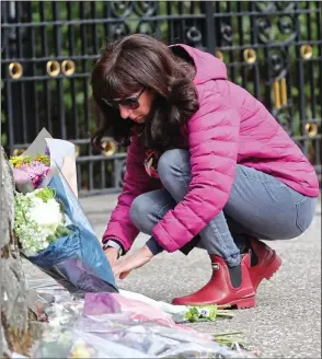  ??  ?? HIGHLAND HOME: A mourner leaves a tribute outside royals’ beloved Balmoral