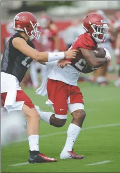  ?? NWA Democrat-Gazette/Andy Shupe ?? SMOOTH EXCHANGE: Arkansas quarterbac­k Nick Starkel, left, hands the ball off Friday to running back A’Montae Spivey during practice at the university practice field in Fayettevil­le.