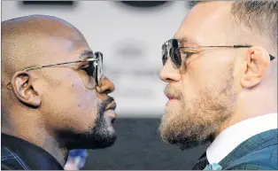  ?? ASSOCIATED PRESS PHOTO/JOHN LOCHER ?? Floyd Mayweather Jr., and Conor Mcgregor (right) pose for photograph­ers during a news conference Wednesday. The two are scheduled to box tonight in Las Vegas and whatever the result, Mcgregor will be a big-time beneficiar­y.