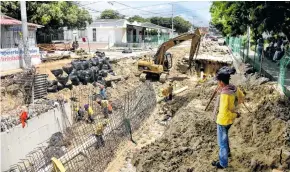  ?? CÉSAR BOLÍVAR ?? Un obrero observa la obra que se realiza en la carrera 21. Al fondo, las viviendas afectadas son protegidas con sacos de arena.