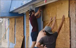  ?? AP PHOTO DASH COLEMAN ?? Employees board up Aloha Gifts Thursday Tybee Island, Ga., ahead of Hurricane Irma’s possible impact on coastal Georgia.