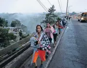  ?? [AP PHOTO] ?? Honduran migrants leave Guatemala City at sunrise Thursday as they continue their way north toward the U.S. Many of the more than 2,000 Hondurans in a migrant caravan trying to wend its way to the United States left spontaneou­sly with little more than the clothes on their backs and what they could quickly throw into backpacks.