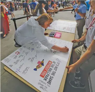  ?? THE ASSOCIATED PRESS ?? Carolyn Donnell signs a get well card for Cleveland Indians manager Terry Francona before Friday night’s game against the Detroit Tigers in Cleveland. Francona underwent a procedure Thursday to correct an irregular heartbeat and will miss out on...