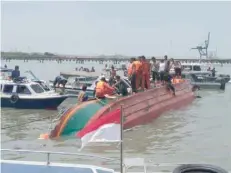  ?? — Reuters ?? People stand atop a capsized boat near Tarakan, North Kalimantan, on Tuesday in this picture obtained from social media.