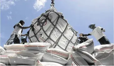  ?? ?? Sacks of Imported rice from Vietnam are being unloaded in Surigao City port.