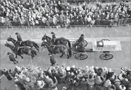  ?? Andy Rain European Pressphoto Agency ?? A COFFIN holding the bones of King Richard III, killed in battle in 1485, is transporte­d toward Leicester Cathedral in central England. The Leicesters­hire County Council said more than 35,000 people lined the streets and country lanes to see the...