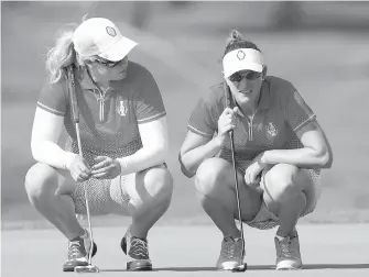  ??  ?? United States’ Brittany Lincicome, left, consults with teammate Brittany Lang on the ninth green during their four-ball match in the Solheim Cup tournament on Friday in West Des Moines, Iowa.