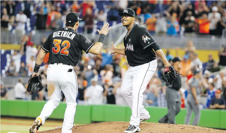  ?? — THE ASSOCIATED PRESS ?? Derek Dietrich, left, congratula­tes Edinson Volquez after the Marlins’ pitcher tossed a no-hitter, blanking Arizona 3-0 on Saturday night in Miami.