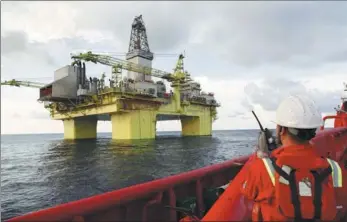  ?? XINHUA ?? A technician from CNOOC oversees the operation of a drilling platform in South China Sea.