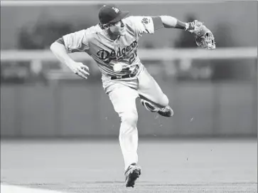  ?? David Zalubowski
Associated Press ?? DODGERS SECOND BASEMAN Chase Utley bobbles a grounder by Justin Morneau that goes for a single in the first inning. The Colorado Rockies scored four runs in the inning on Nolan Arenado’s grand slam.