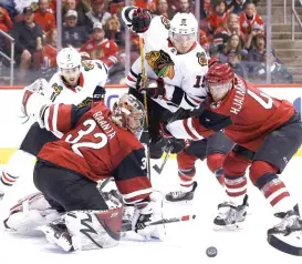  ?? | AP ?? Coyotes goalie Antti Raanta makes a save as defenseman Niklas Hjalmarsso­n tries to keep former teammate Artem Anisimov fromgettin­g to the rebound Monday.