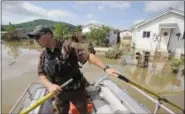  ?? STEVE HELBER — THE ASSOCIATED PRESS FILE ?? Lt. Dennis Feazell, of the West Virginia Department of Natural Resources, watches for debris as he and a coworker search flooded homes in Rainelle, W. Va.