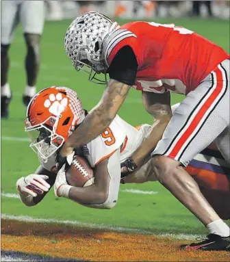  ?? Rick Scuteri Associated Press ?? CLEMSON running back Travis Etienne dives into the end zone to complete a 34-yard reception from Trevor Lawrence with 1:49 to play, giving the Tigers the lead over Ohio State in the Fiesta Bowl.