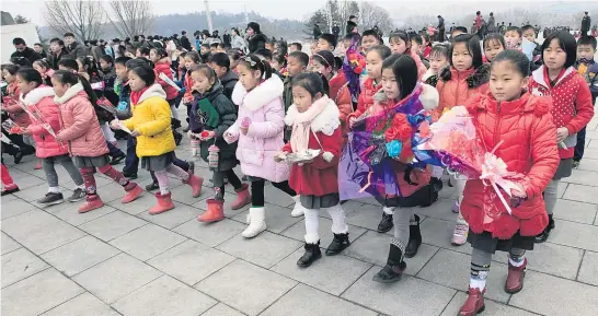  ?? Pictures / AP ?? In Pyongyang, children paid tribute to Kim Jong Il on Thursday by placing flowers at the foot of a statue of him.