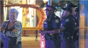  ?? COLE BURSTON/AFP/GETTY IMAGES ?? Toronto police officers stand watch after a gunman opened fire on the Danforth on Sunday night.