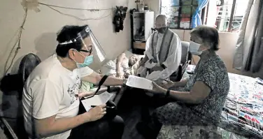  ??  ?? DOCTOR’S ADVICE Dr. Eduardo Gatchalian (left) gives retired schoolteac­her Amparo Aberia a medical prescripti­on for her bedridden husband Crisanto. Gatchalian, an eminent urologist, is now active in Church activities supervised by the parish priest.