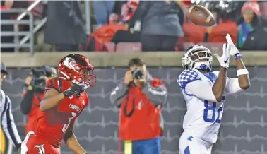  ?? AP PHOTO/TIMOTHY D. EASLEY ?? Kentucky wide receiver Josh Ali reaches for a pass ahead of the defense of Louisville cornerback Cornelius Sturghill during the second half in Louisville, Ky., on Saturday. Kentucky won 56-10.