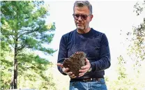  ?? Staff photo by Hunt Mercier ?? ■ Chris Powell, an associate professor from Texas Christian University, holds a pottery piece he made from his tsuchigama kiln and talks about the history of the Japanese kiln.