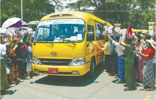  ?? AFPPIC ?? Relatives gather around a bus transporti­ng prisoners being released from Insein prison for the Buddhist New Year in Yangon yesterday. –