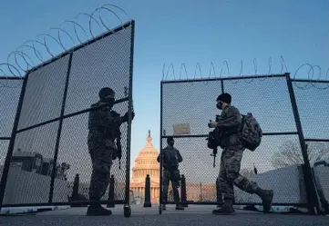  ?? CAROLYN KASTER/AP ?? National Guard soldiers open a gate of the perimeter fence around the U.S. Capitol this month in Washington. Security fencing is set to be removed from the Capitol, but metal detectors remain stationed outside the House chamber.