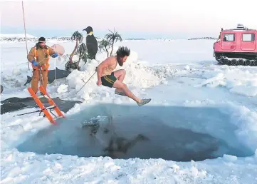  ??  ?? An undated handout photo received from the Australian Antarctic Division shows an expedition­er stationed at Australia’s Davis Station taking the plunge to celebrate the winter solstice. — AFP photo