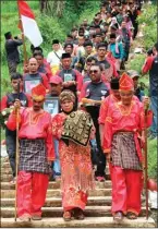  ??  ?? REKIAN/JAWA POS RADAR KEDIRI RITUAL ADAT: Para niniak mamak menuruni tangga sambil membawa tanah kubur Tan Malaka di lereng Gunung Wilis, Selopanggu­ng, Kediri, Selasa (21/2).