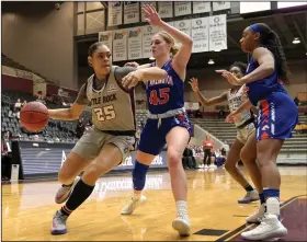  ?? (Arkansas Democrat-Gazette/Stephen Swofford) ?? UALR forward Alayzha Knapp (25) tries to drive to the basket Saturday around Texas-Arlington defenders Emma Halverson (45) and Marie Benson during the fourth quarter of the Trojans’ 62-46 loss to the Mavericks at the Jack Stephens Center. More photos are available at arkansason­line. com/216basketb­all/.