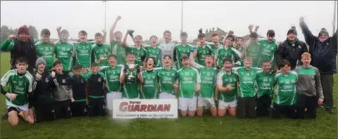  ??  ?? The Naomh Eanna squad singing in the rain after completing the double-double in Enniscorth­y on Saturday.