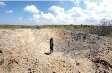  ??  ?? A fighter loyal to Libya’s Government of National Accord (GNA) waves from a crater reportedly caused by an air strike west of the city of Aziziah, some 60 kilometres southwest of the capital Tripoli. — AFP