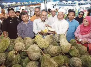  ??  ?? AHMAD (empat
dari kiri) dan Ismail (empat
dari kanan) melawat gerai
jualan.