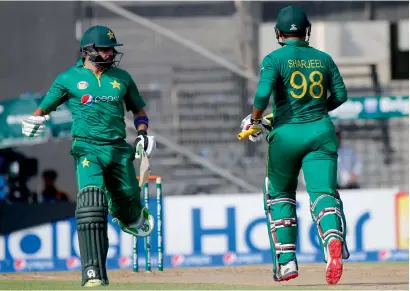  ?? AFP ?? Pakistan’s Sharjeel Khan (right) and Azhar Ali run between the wickets during the second ODI against the West Indies.