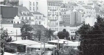  ??  ?? Residentia­l properties are seen in this 2014 photo standing on the hill leading to Saint George’s hilltop castle near Martim Moniz square in Lisbon, Portugal. As some European cities impose restrictio­ns on short-term rentals via websites such as Airbnb...