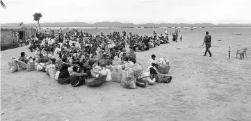  ?? — Reuters photo ?? Rohingya refugees wait at a Border Guard Bangladesh post after crossing the Bangladesh-Myanmar border by boat through the Bay of Bengal in Shah Porir Dwip, Bangladesh.