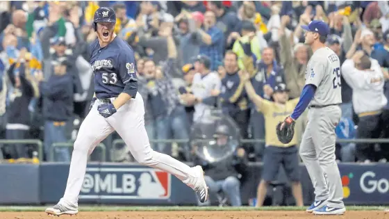  ??  ?? The Brewers’ Brandon Woodruff celebrates after hitting a home run during the third inning against the Dodgers.