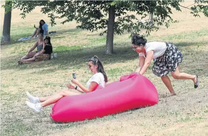  ?? RICHARD LAUTENS TORONTO STAR ?? Anjeli Kruytbosch gets a push down a hill in Riverdale by Aditi Raina as she tries her hand at grass sledding on a sweaty Sunday.