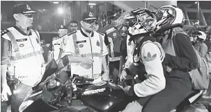  ?? — Gambar Bernama ?? DISOAL: Mazlan menyoal seorang penunggang motosikal dalam Operasi Trafik di Jalan Raja Laut awal pagi kelmarin.