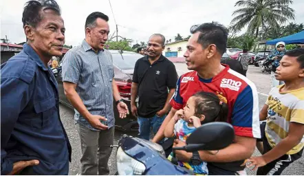  ?? — Bernama ?? Reaching out: Mohd Sharim (second from left) chatting with Felda Chini 3 residents in Pekan.