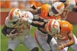  ?? STAFF FILE PHOTO BY C.B. SCHMELTER ?? Tennessee’s Trey Coleman (24) tries to get away from linebacker Shanon Reid (21) and defensive back Alontae Taylor (6) in the spring game. The Vols finally will line up against another team today.