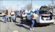  ?? Ned Gerard / Hearst Connecticu­t Media ?? Volunteers load food into vehicles during the CT Food Bank/Foodshare food donation at Calf Pasture Beach in Norwalk on Feb. 17.