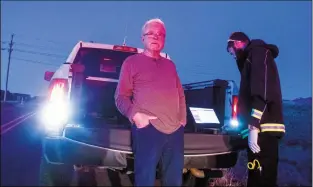  ?? Rick Romancito ?? Ed Ramsey leans against the tailgate of a Taos County Sheriff’s Department pickup as he is evaluated by an unidentifi­ed EMT Monday evening (Nov. 19) on Blueberry Hill Road south of Taos. Ramsey reportedly rolled his PT Cruiser down an embankment around 5 p.m. Ramsey was arrested on a charge of driving while intoxicate­d and transporte­d to the Taos County jail.