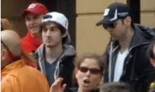  ?? BosTon hErALd fiLE ?? SUSPECT IN A ‘WHITE HAT’: Dzhokhar Tsarnaev, second from left, wearing a white hat, and Tamerlan Tsarnaev, center, stand in the crowd as Boston Marathon runners headed to the finish line on Boylston Street in Boston on April 15, 2013.